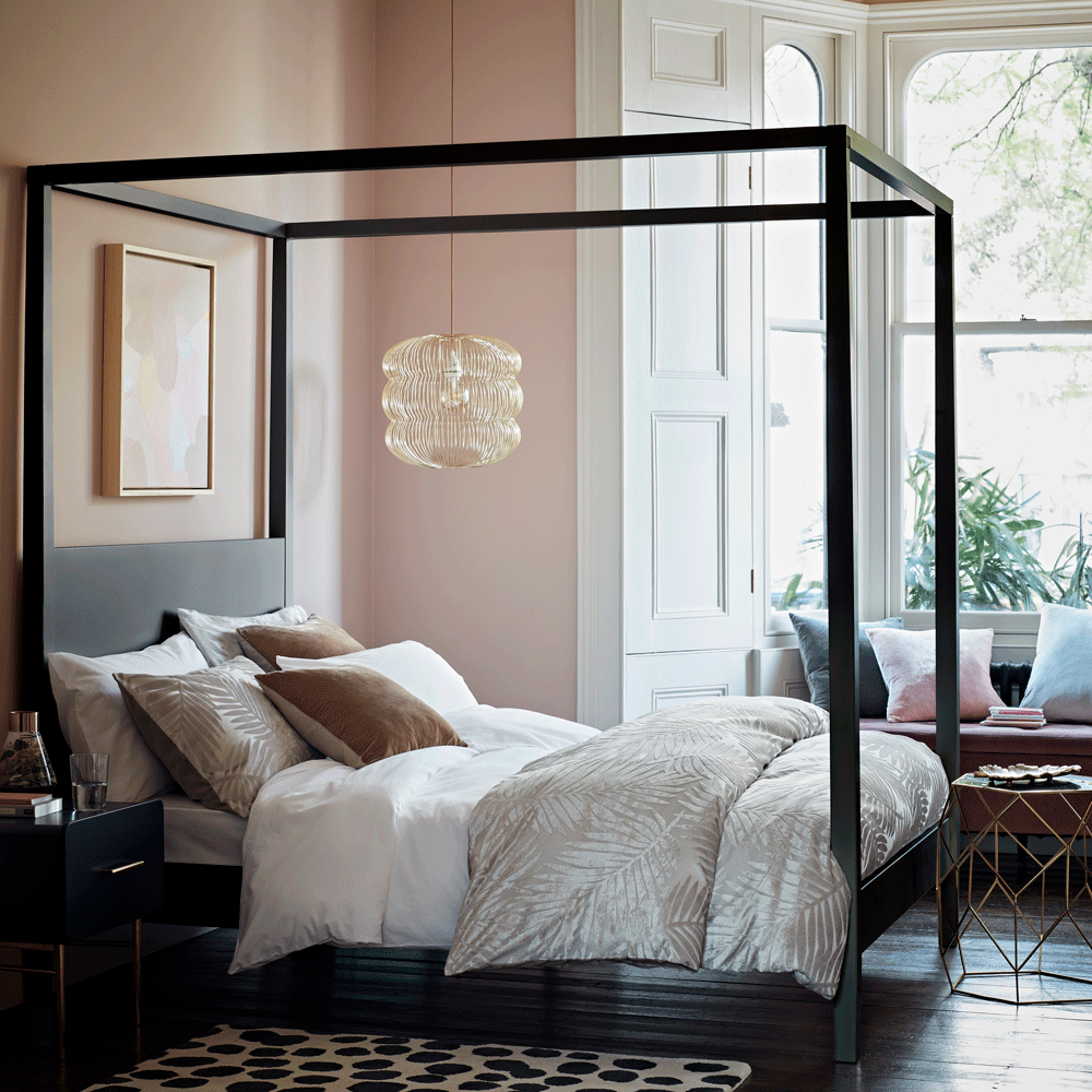 bedroom with wooden flooring and four poster bed