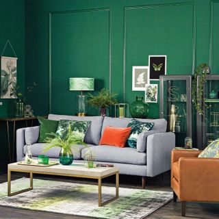 Emerald green living room with smart grey sofa and orange accents