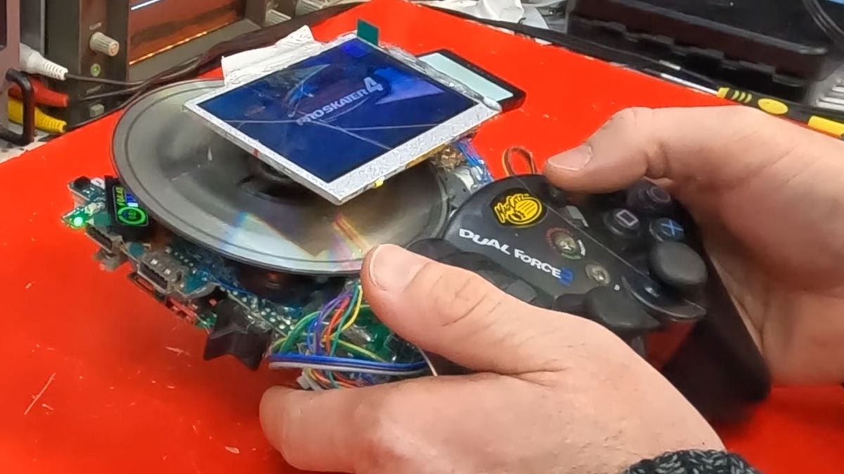 Close up of DIY PS2 handheld with disc spinning under screen and Tony Hawks Pro Skater 4 logo displayed.