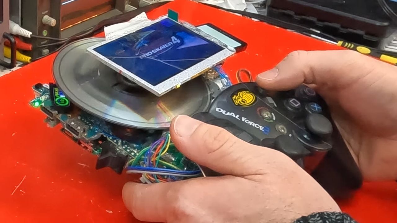 Close up of DIY PS2 handheld with disc spinning under screen and Tony Hawks Pro Skater 4 logo displayed.