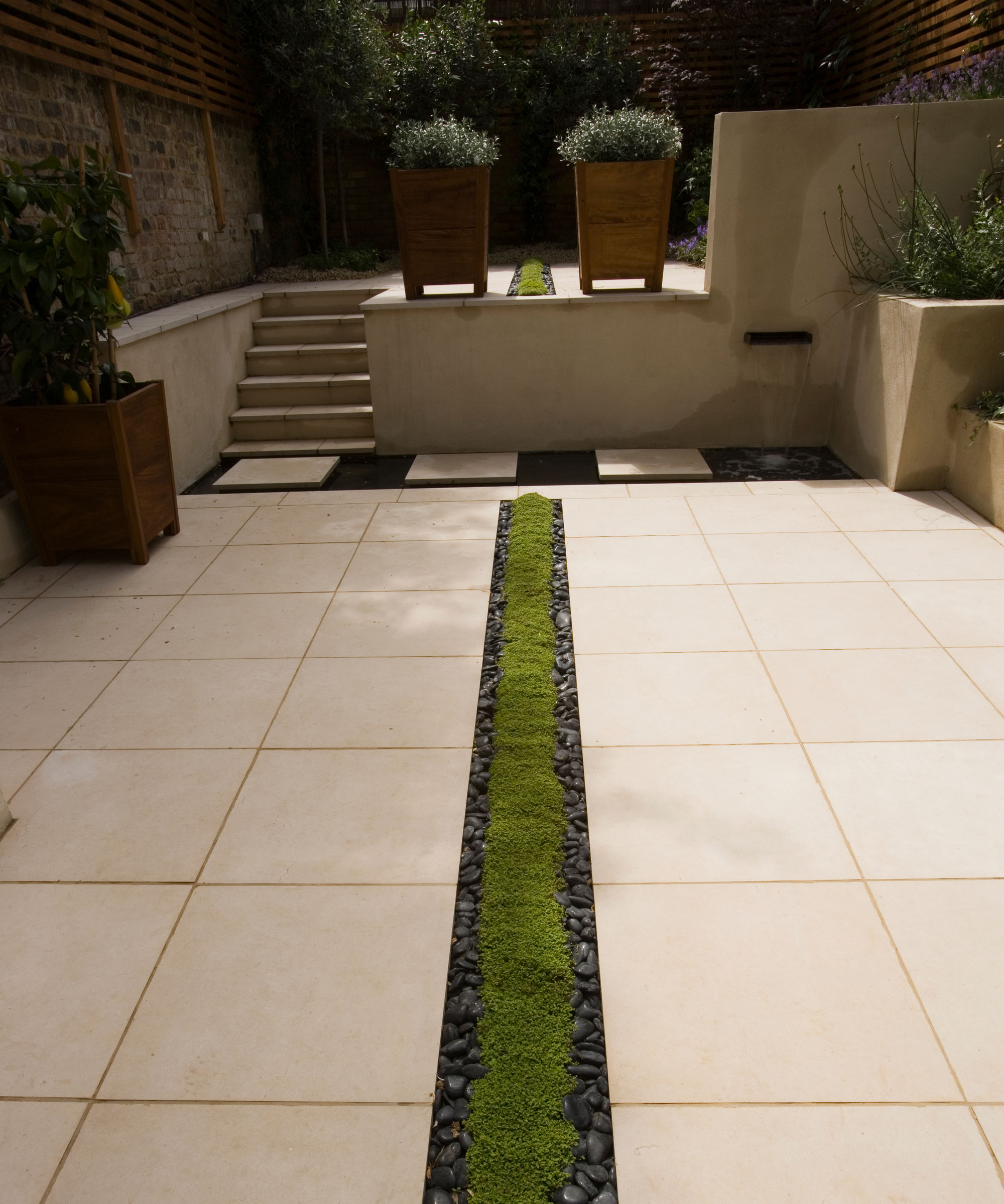patio with channel drain, steps, planters and paving