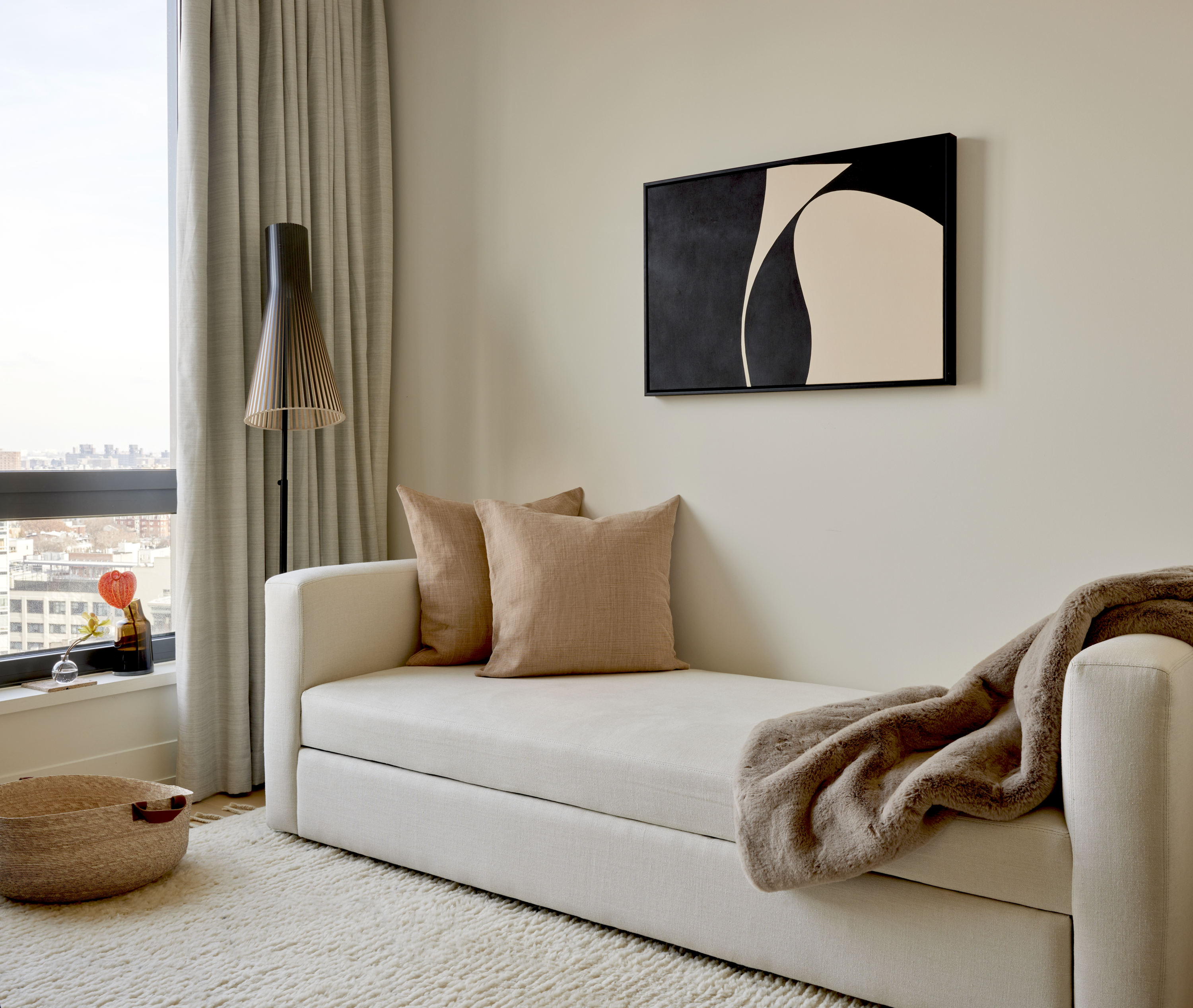 A beige-toned living room with light pink pillows