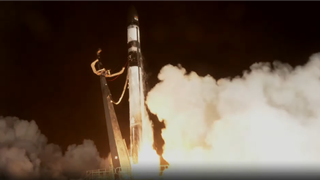 a black and white rocket launches at night