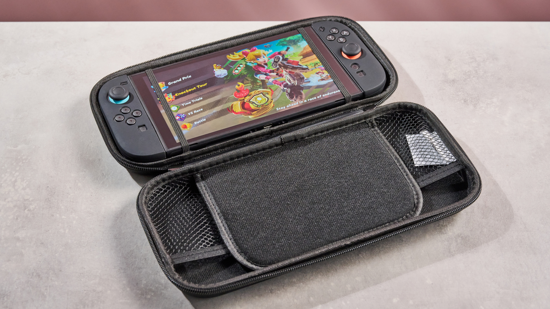 The Nintendo Switch 2 sits inside the Snakebyte Starter Kit S2 case, with Mario Kart World showing on its screen.