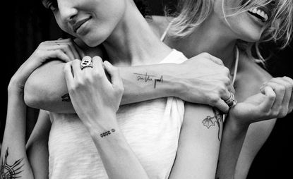 black and white image of multiple people with ephemeral tattoos which fade after a year