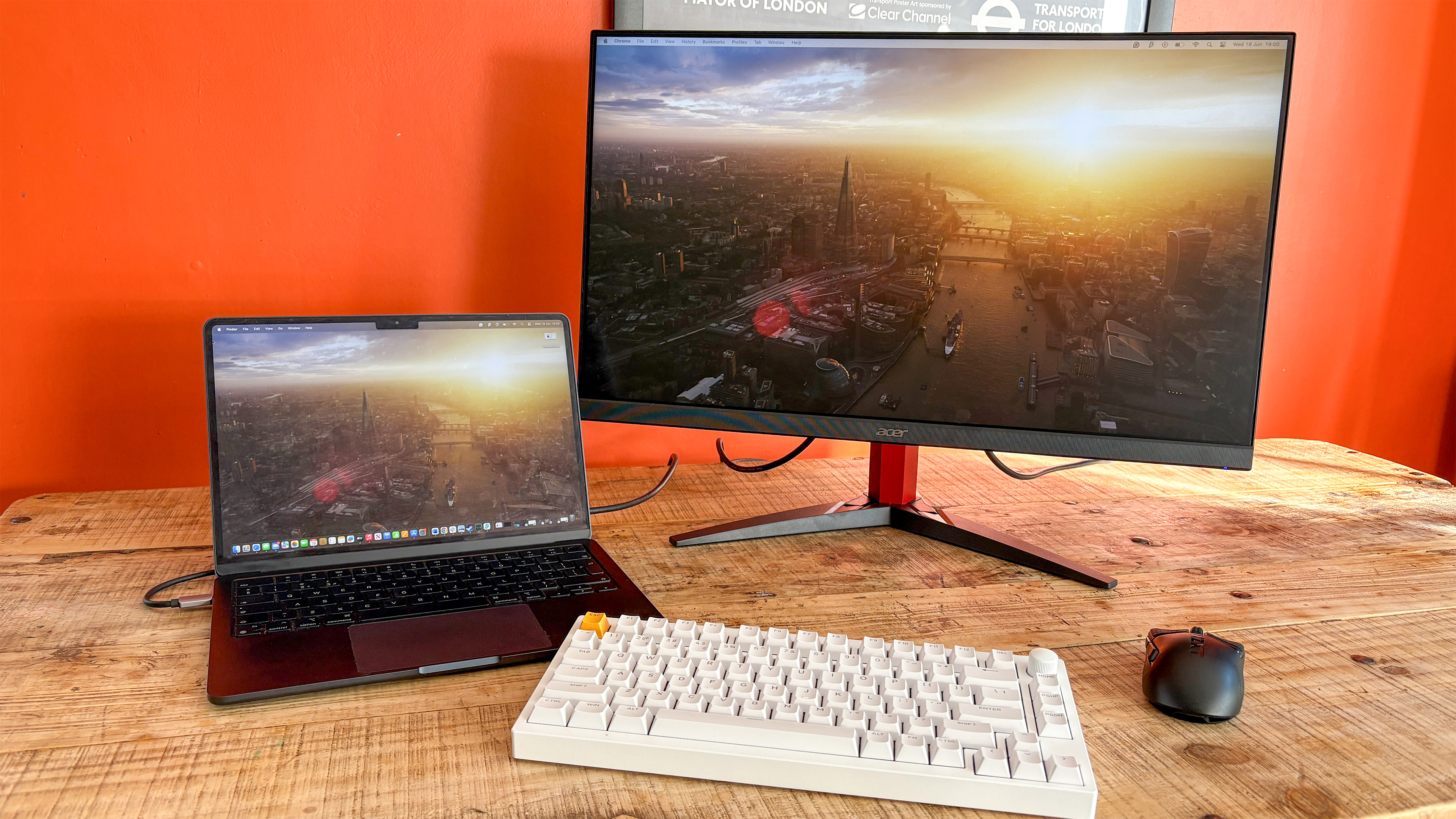 Acer Nitro KG272 E on table next to MacBook Air with keyboard and mouse in front