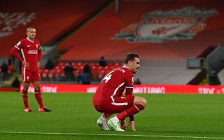 Liverpool captain Jordan Henderson crouches on the pitch