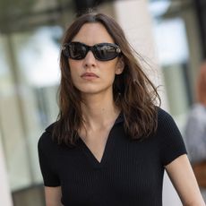 Alexa Chung wearing a black mini dress and sunglasses