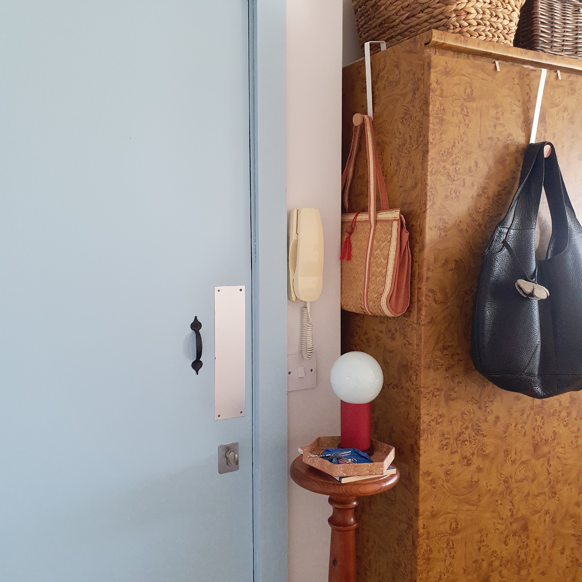 Sara's entrance area with a side table with a lamp next to a blue front door