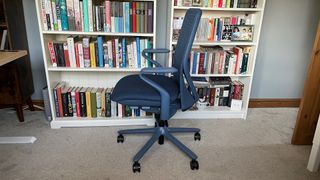 A side shot of the Verve chair against a book shelf. 