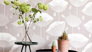 Japandi living room with mushroom colored poppy illustrated wallpaper behind black round side tables