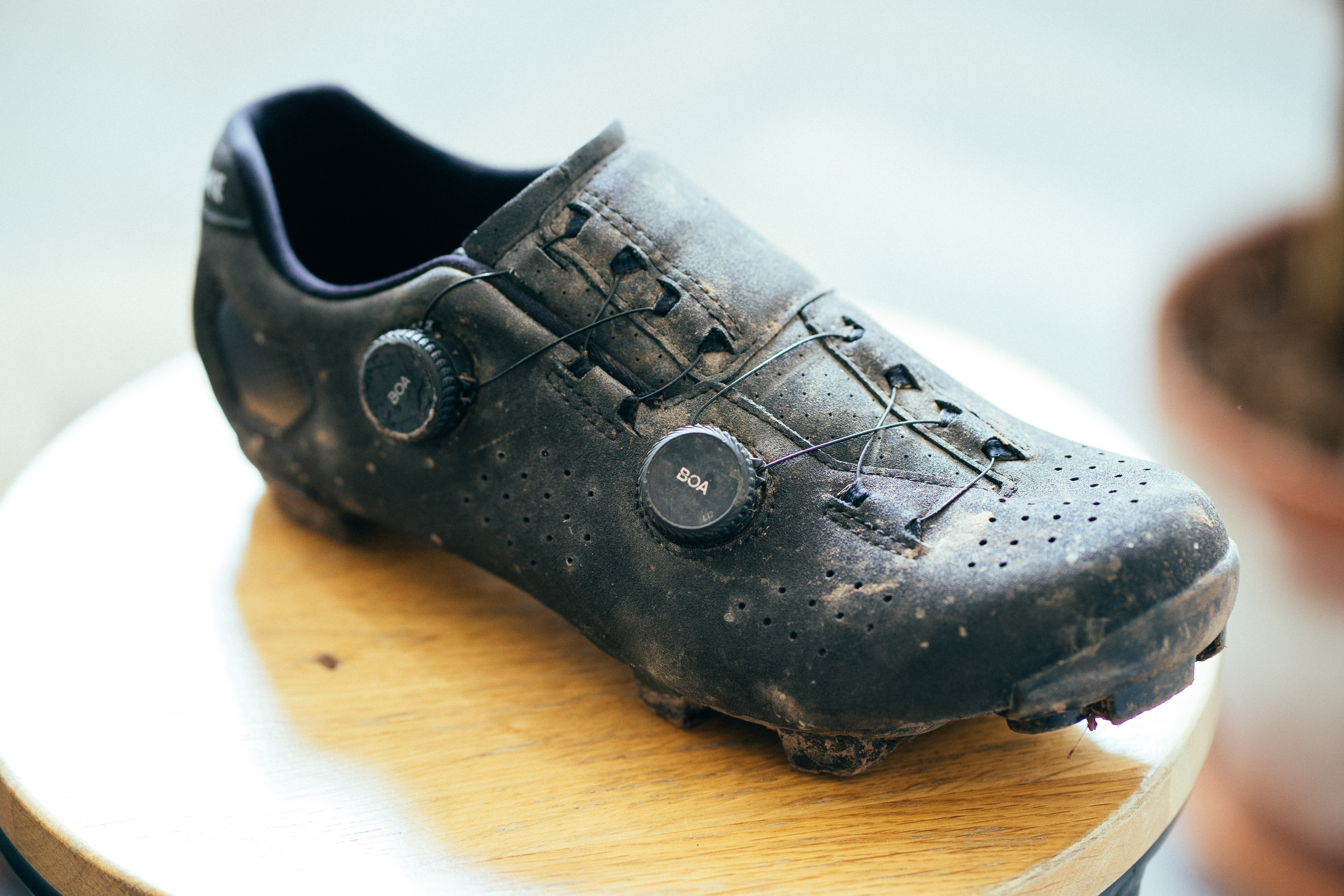 A top down view of a black gravel shoe on a wooden stool