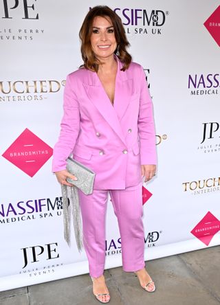 Coleen Rooney in pink suit holding silver bag