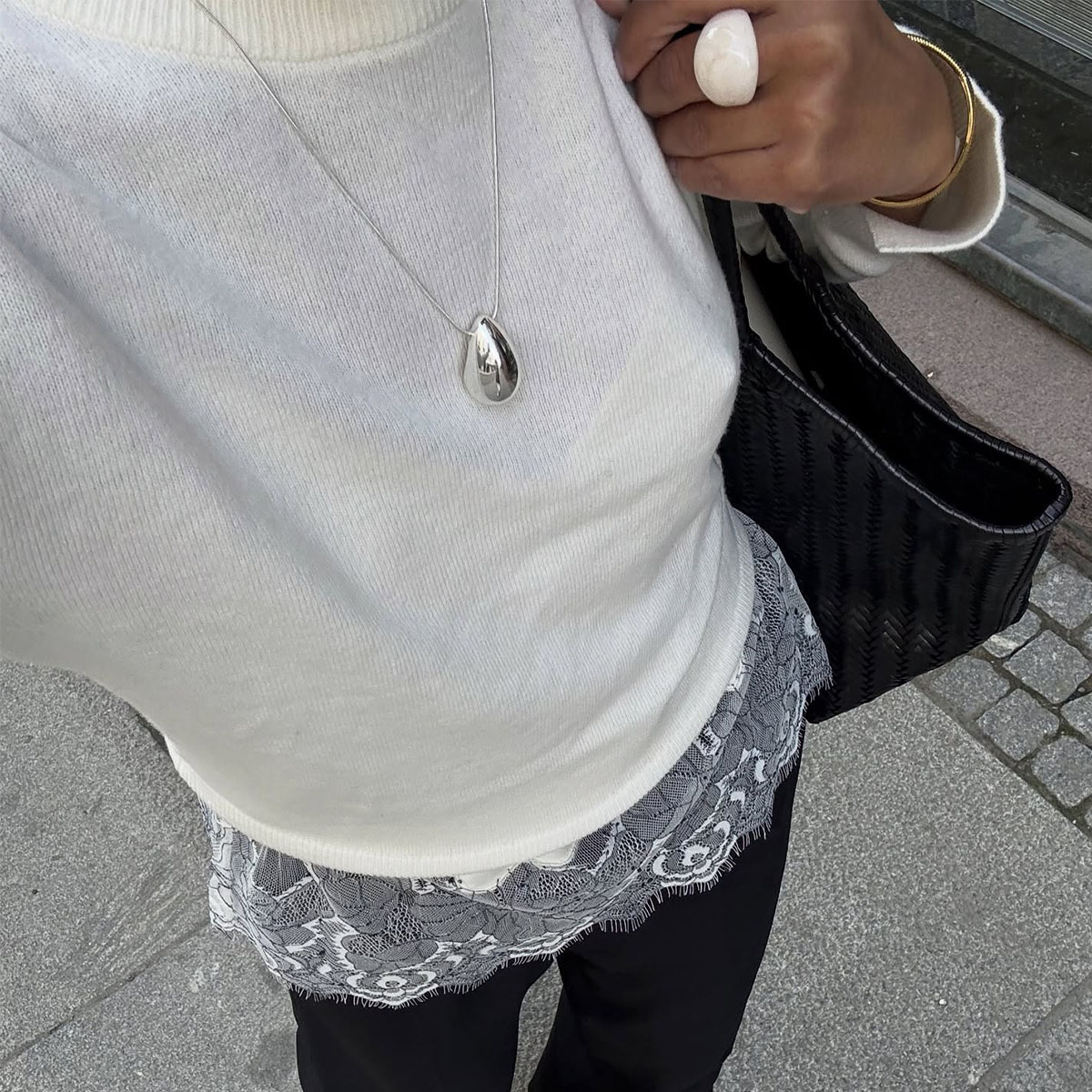 Woman in a sweater, black pants and lace-trim top