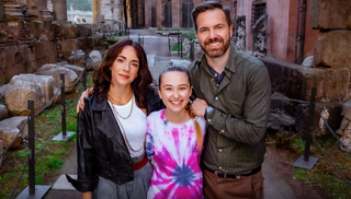 Francesca (played by Eleonora Facchini) and William (Darrin Rose) are pictured either side of a beaming Lucy (Kensington Tallman) who wears a pink and white tie-dye top