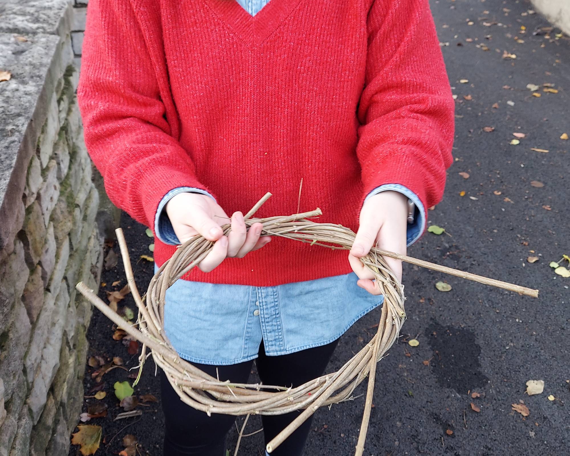 Woman making an advent wreath by wrapping honeysuckle branches around each other