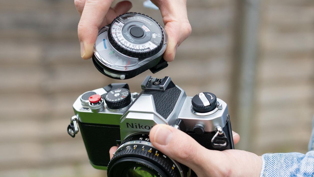Man holding Nikon FM with Sekonic Twinmate L-208 mounted on hot shoe