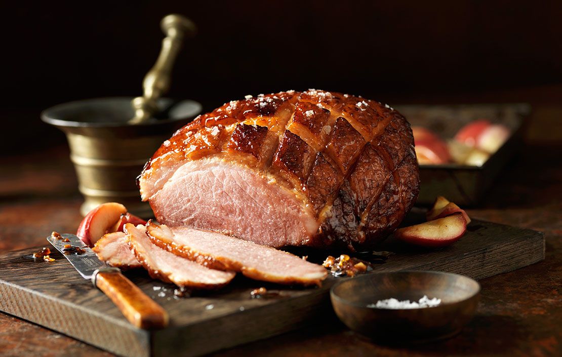 Roast ham, slices carved, on chopping board