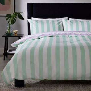 A bed with mint green stripe duvet cover