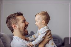 Father holding baby and both have wide open mouths
