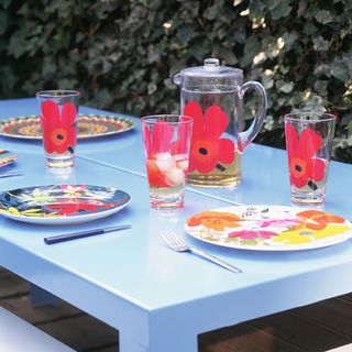 light blue rectangular garden table with red floral design tableware