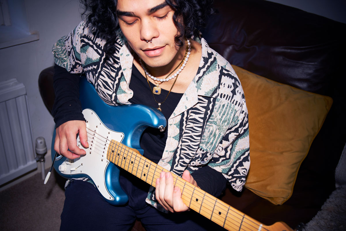 Man plays a blue Fender Stratocaster