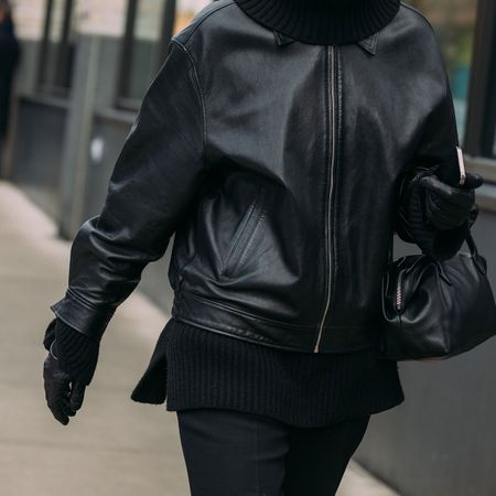 NYFW street style girl in all black, leather jacket, gloves and bag closeup shot 