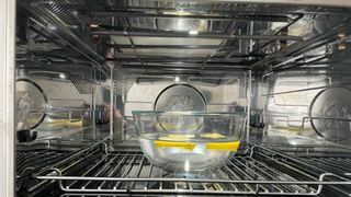 a bowl of lemon and water in a microwave
