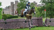 Laura Collett and London 52 clear a castle-shaped cross-country fence with Scone Palace in the background.