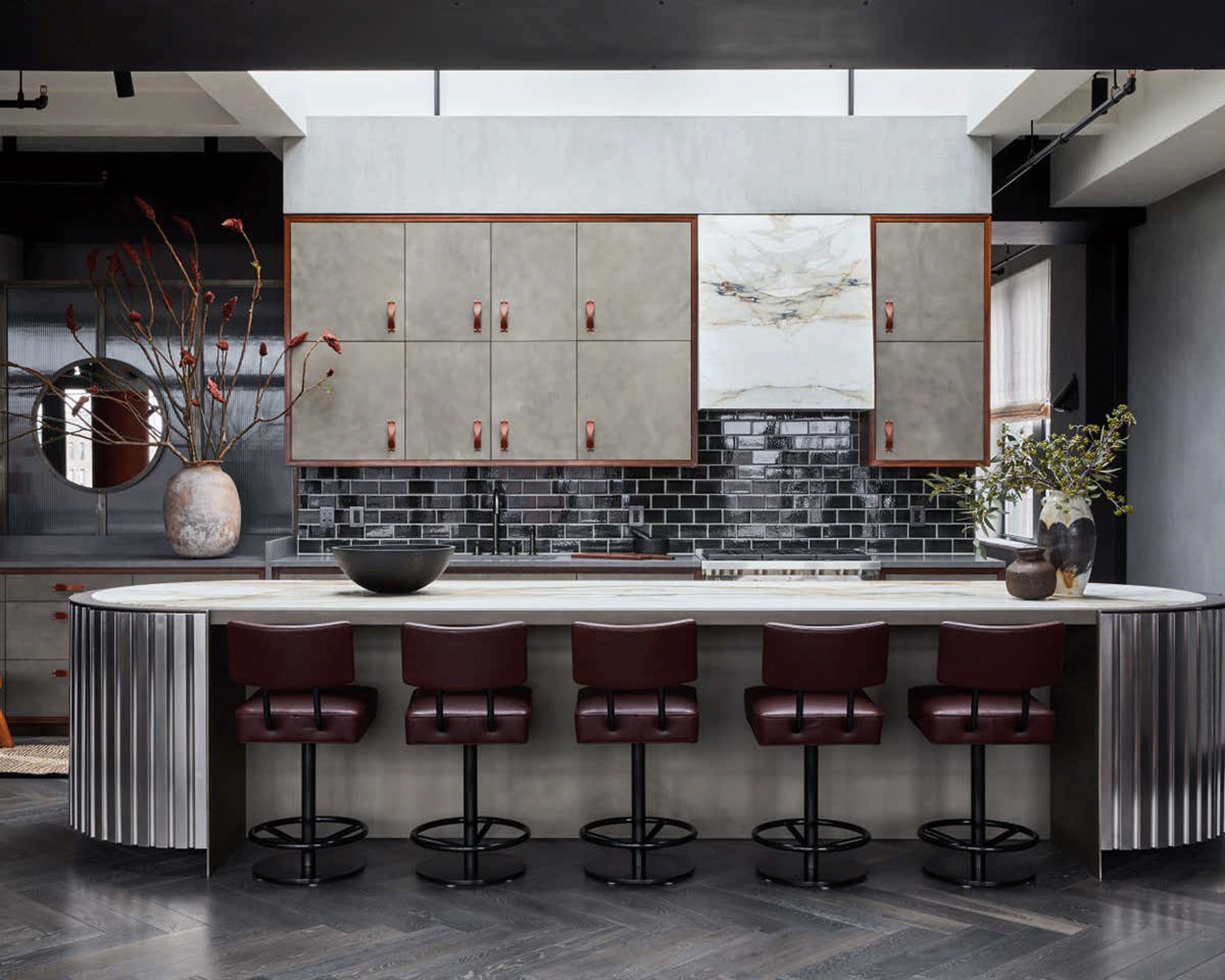 Kitchen with large metallic island with metallic fluting