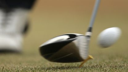 Close-up of a driver hitting a ball off a tee