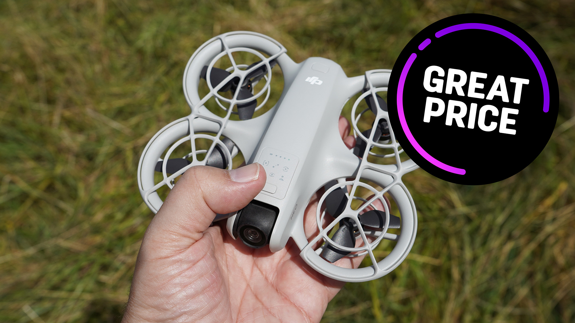 DJI Neo drone held in hand in front of grass