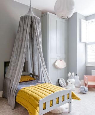 girls grey bedroom with wardrobe and canopy over bed