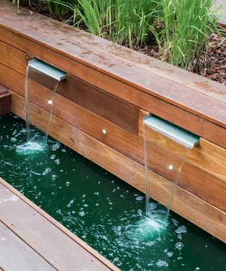 Mini waterfall built into the side of a raised bed on the deck