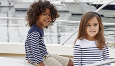 2 children wearing striped jumpers from Jojo Maman Bebe on a boat.