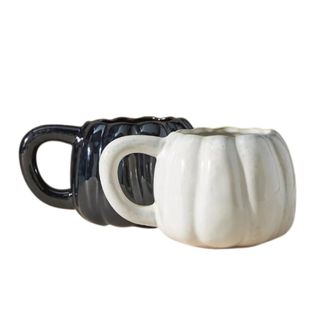 A pair of black and white pumpkin mugs