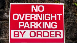 Red sign reads "No overnight parking, by order"