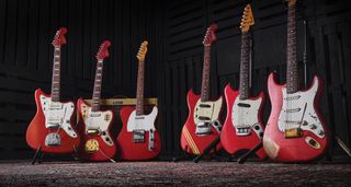 Vintage Fender electrics in Candy Apple Red lined up together and photographed with a tweed combo.