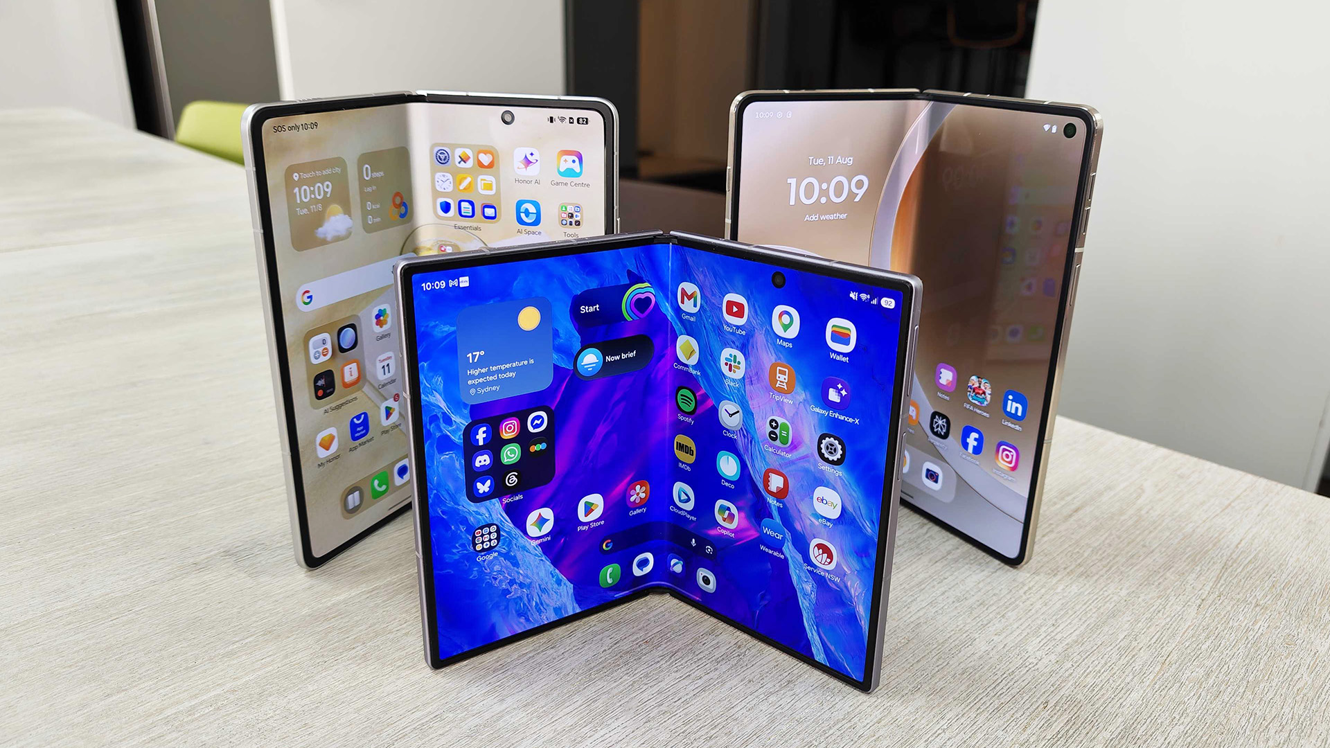 Three foldables, Samsung Galaxy Z Fold 8, Honor Magic V6 and Motorola Razr Fold on a desk.