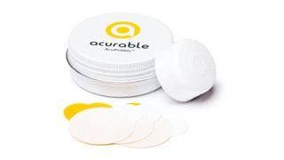 Image shows the Acurable AcuPebble obstructive sleep apnea detection device with the carry case and replacement adhesive pads
