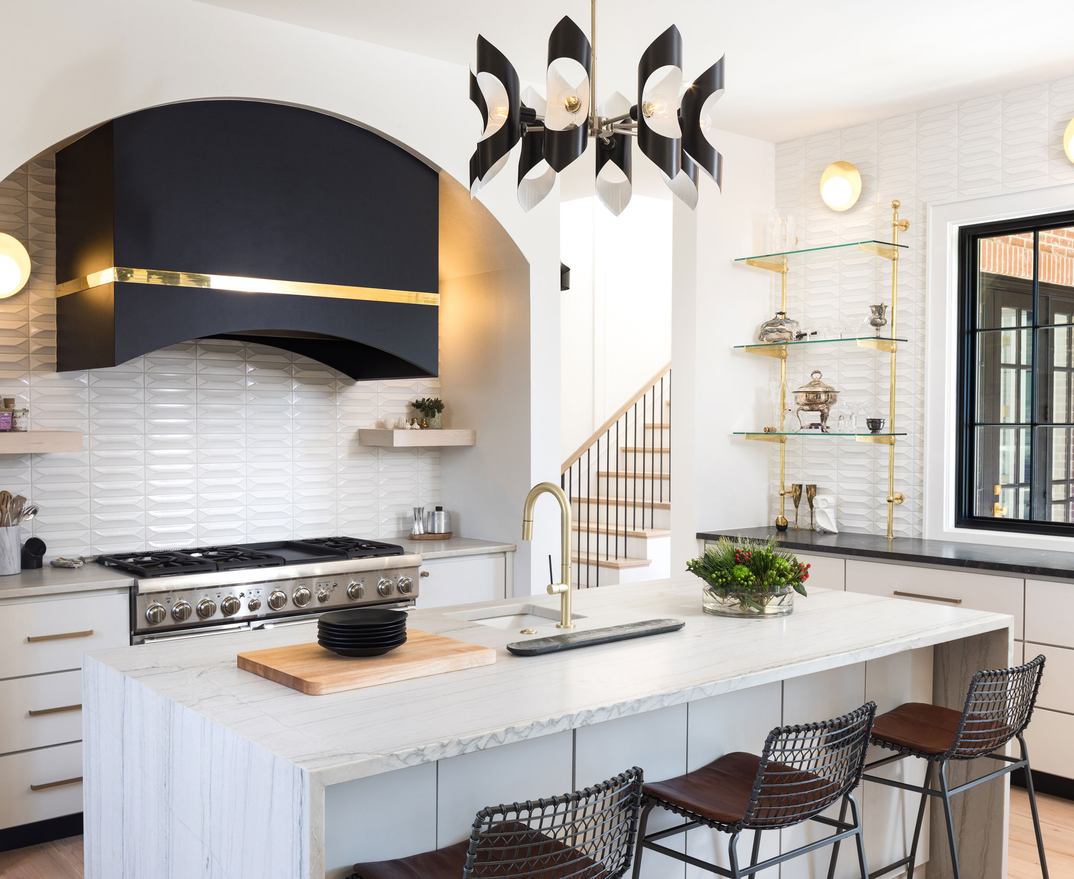 Modern kitchen with white tiled walls and hints of black and gold throughout the kitchen illustrating metallic black and white kitchen ideas.