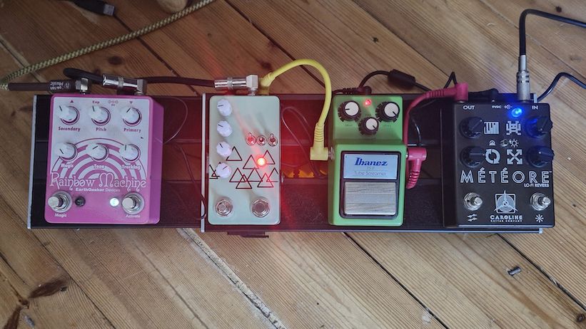 A top down view of a D'Addario XPND1 pedalboard with pedals attached