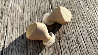 Jabra Elite 5 earbuds on a wooden bench