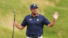 Bryson DeChambeau holds both hands up during round two of the 2025 Open Championship at Royal Portrush