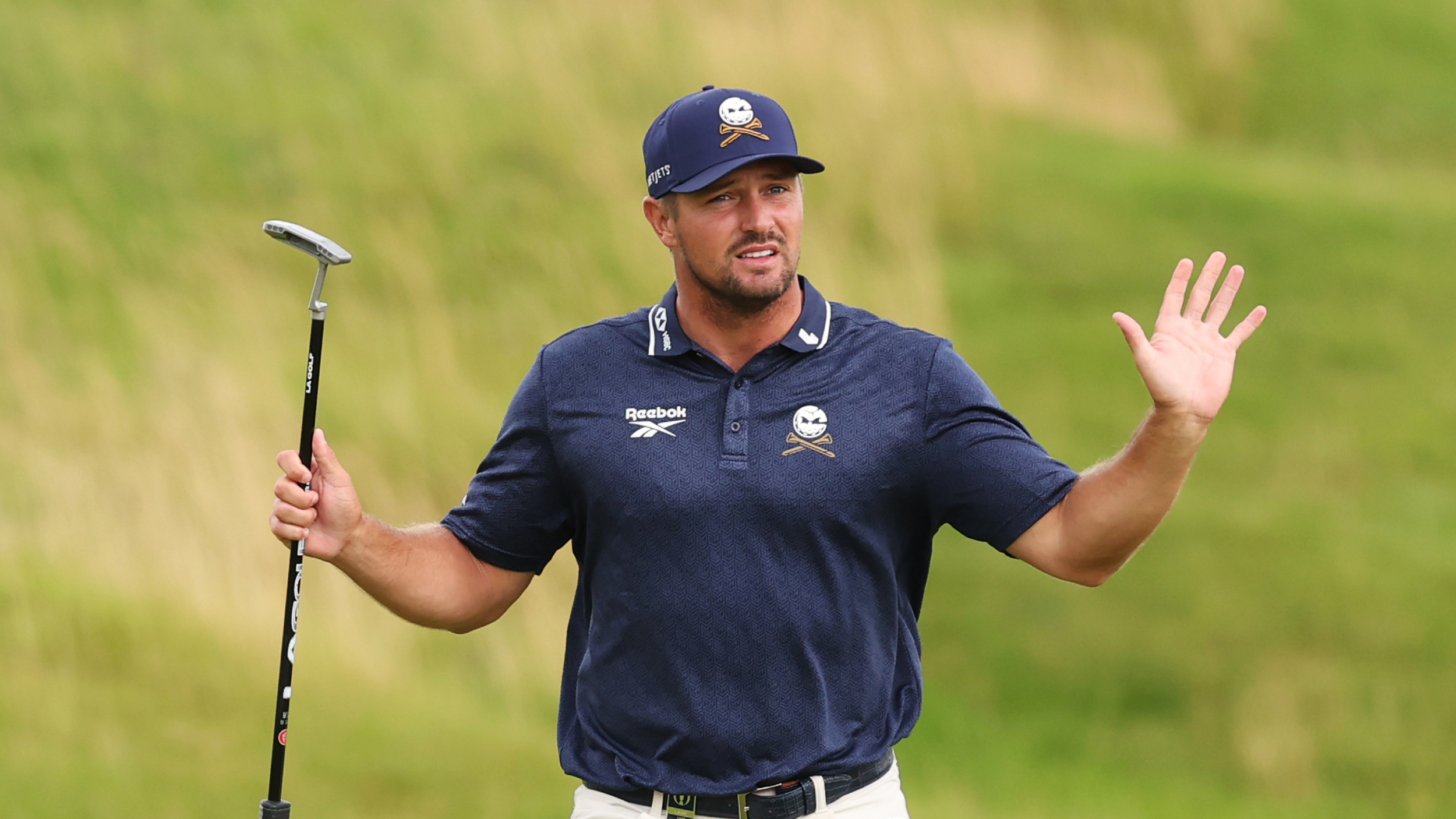 Bryson DeChambeau holds both hands up during round two of the 2025 Open Championship at Royal Portrush