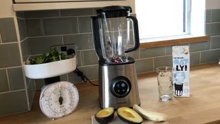 Philips HR3752/01 High-speed vacuum blender on a kitchen countertop woth vegetables and oat milk