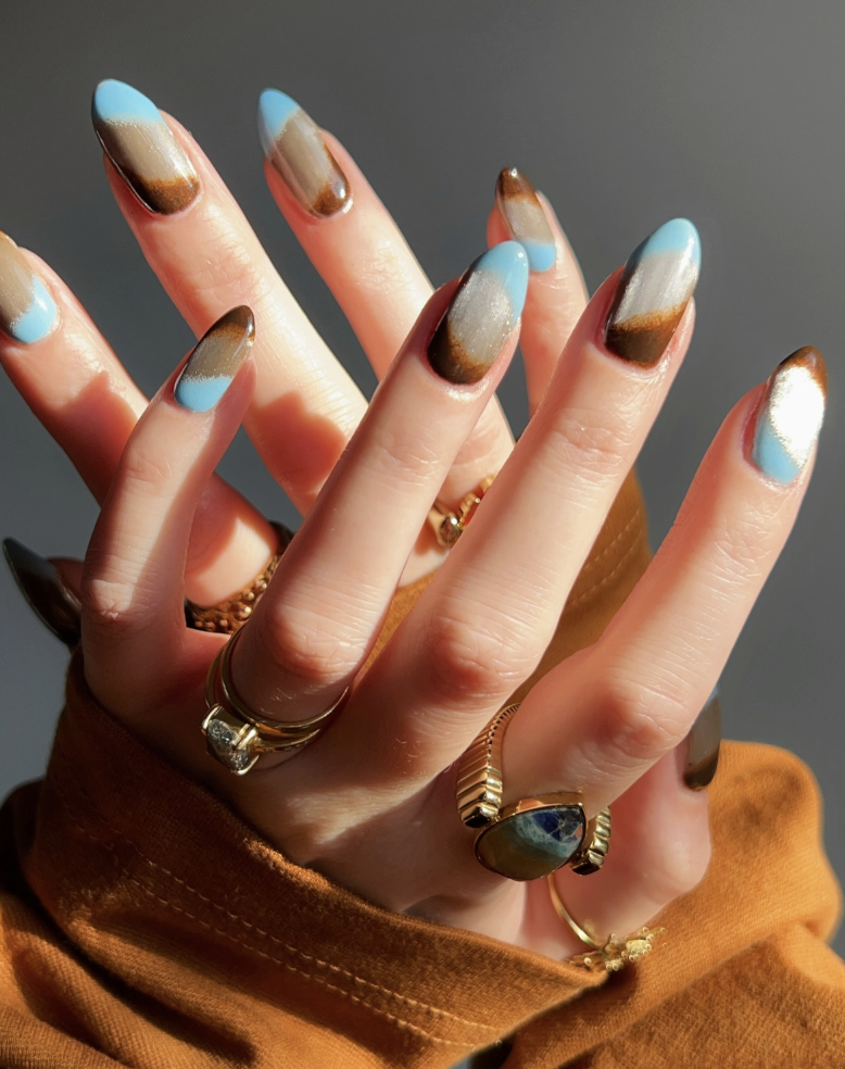 gradiant blue nails with rings and a yellow sweater