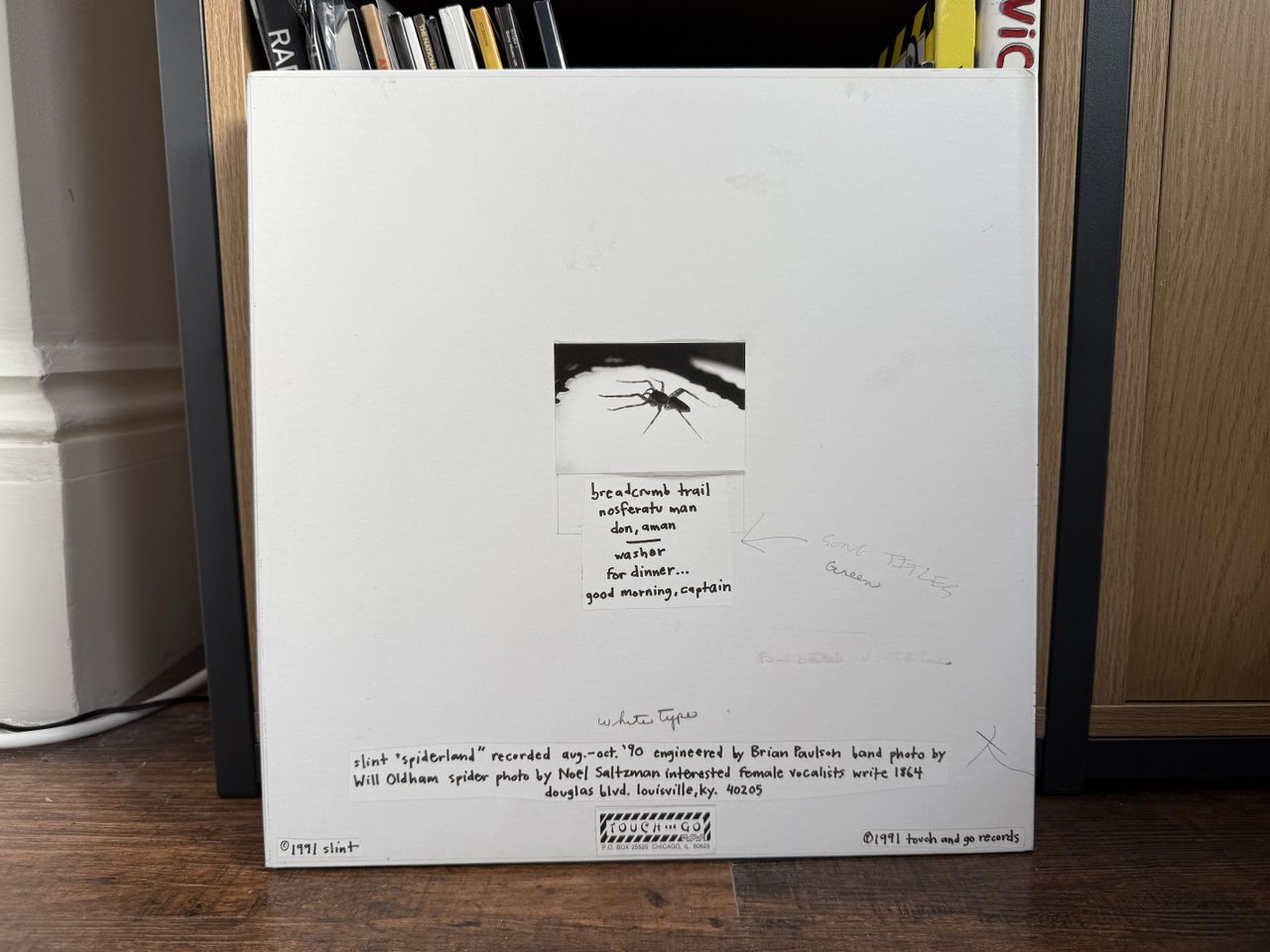 The white back cover of Slint's Spiderland album. It is propped up against a cabinet containing more vinyl records.