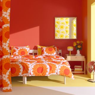 Sunflower print bed sheets and pillows in an orange room