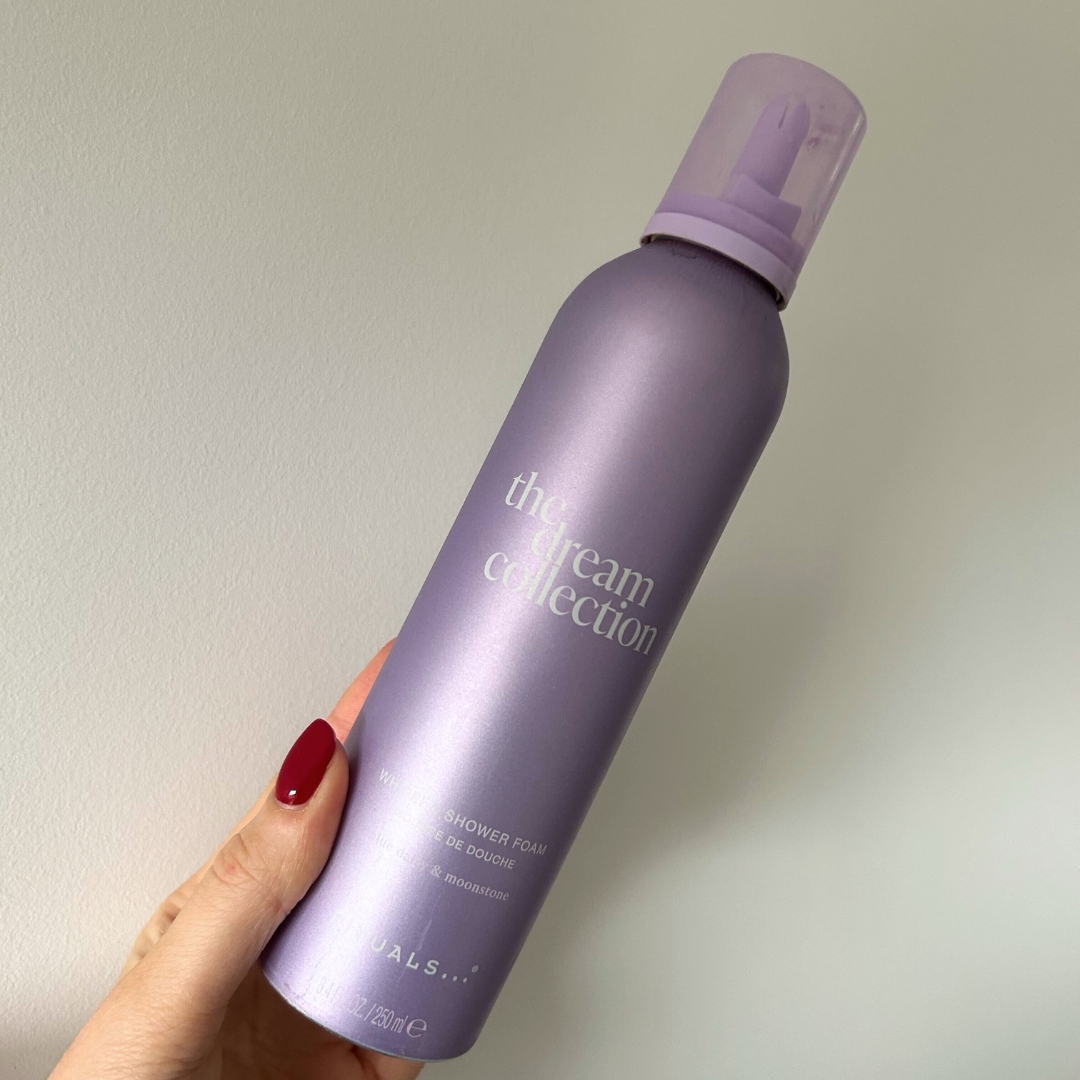 Hand holding lilac bottle of Rituals Dream Foaming Shower Gel